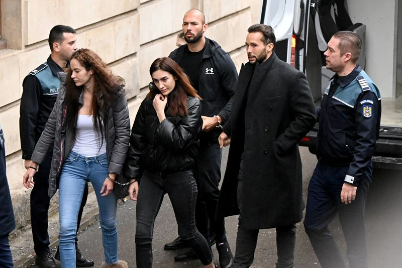 British-US former professional kickboxer and controversial influencer Andrew Tate (3rd R), his brother Tristan Tate (2nd R), and two unidentified Romanian women, arrive handcuffed and escorted by police at a courthouse in Bucharest on January 10, 2023 for a court hearing on their appeal against pre-trial detention for alleged human trafficking, rape and forming a criminal group. (Photo by Daniel MIHAILESCU / AFP) (Photo by DANIEL MIHAILESCU/AFP via Getty Images)

