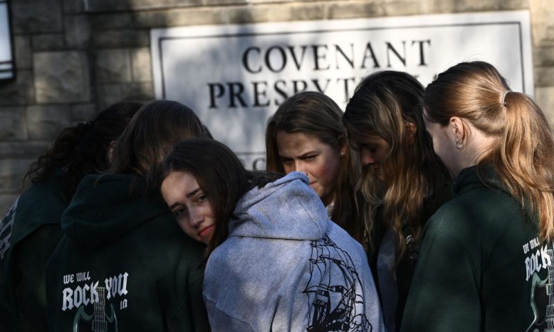 People gather at a makeshift memorial for victims of a shooting at the Covenant School campus, in Nashville, Tennessee, March 29, 2023. - A heavily armed former student killed three young children and three staff in what appeared to be a carefully planned attack at a private elementary school in Nashville on March 27, 2023, before being shot dead by police. Chief of Police John Drake named the suspect as Audrey Hale, 28, who the officer later said identified as transgender. (Photo by Brendan SMIALOWSKI / AFP) (Photo by BRENDAN SMIALOWSKI/AFP via Getty Images)