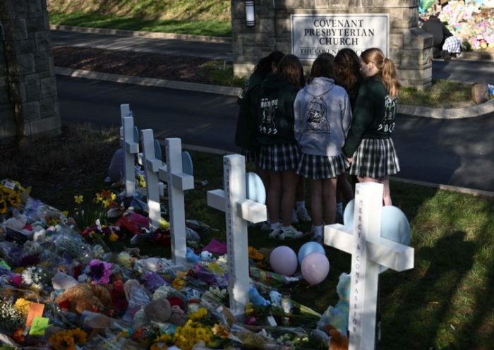 Peopel gather at a makeshift memorial for victims of a shooting at the Covenant School campus, in Nashville, Tennessee, March 29, 2023. - A heavily armed former student killed three young children and three staff in what appeared to be a carefully planned attack at a private elementary school in Nashville on March 27, 2023, before being shot dead by police. Chief of Police John Drake named the suspect as Audrey Hale, 28, who the officer later said identified as transgender. (Photo by Brendan SMIALOWSKI / AFP) (Photo by BRENDAN SMIALOWSKI/AFP via Getty Images)