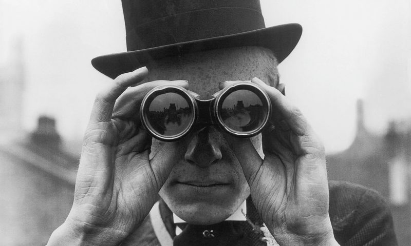 A spectator looking through binoculars at the Derby horse races, Epsom, Surrey, June 1923. (Photo by Topical Press Agency/Hulton Archive/Getty Images)