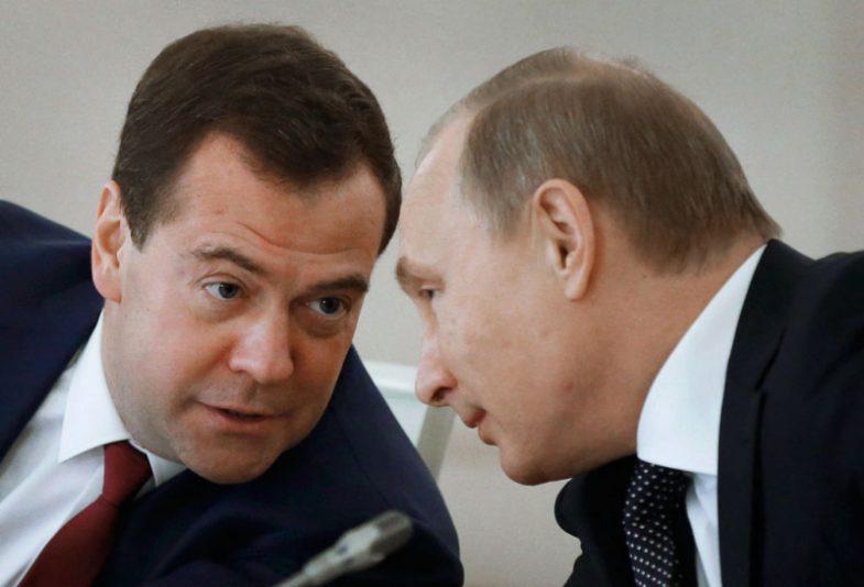 Russian President Vladimir Putin (R) and Russian Prime Minister Dmitry Medvedev confer during a meeting of the State Council and the Presidential Council for Culture and Art at the Kremlin in Moscow on December 24, 2014. AFP PHOTO / RIA-NOVOSTI / DMITRY ASTAKHOV (Photo by DMITRY ASTAKHOV / RIA NOVOSTI / AFP) (Photo by DMITRY ASTAKHOV/RIA NOVOSTI/AFP via Getty Images)