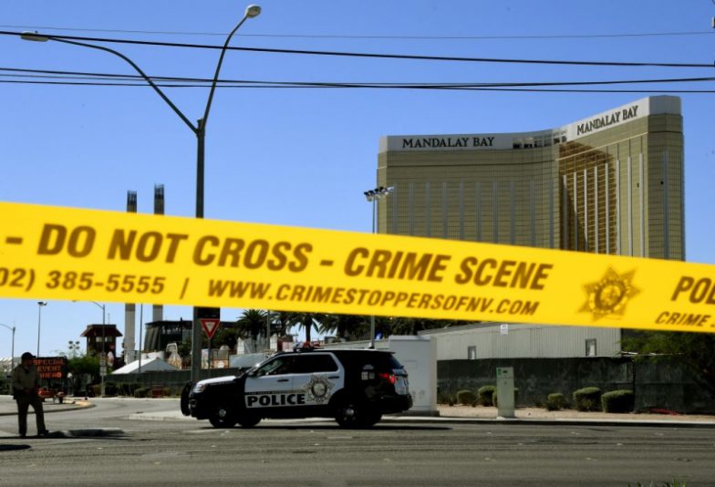 TOPSHOT - Crime scene tape surrounds the Mandalay Hotel (background with shooters window damage top right) after a gunman killed at least 58 people and wounded more than 500 others when he opened fire on a country music concert in Las Vegas, Nevada on October 2, 2017. Police said the gunman, a 64-year-old local resident named as Stephen Paddock, had been killed after a SWAT team responded to reports of multiple gunfire from the 32nd floor of the Mandalay Bay, a hotel-casino next to the concert venue. / AFP PHOTO / Mark RALSTON (Photo credit should read MARK RALSTON/AFP via Getty Images)