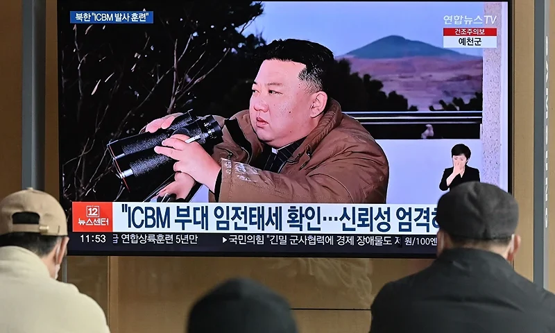 People watch a television news screen showing a picture of North Korea's leader Kim Jong Un witnessing the recent test-firing of a Hwasong-17 intercontinental ballistic missile (ICBM), at a railway station in Seoul on March 17, 2023. - North Korea said the projectile it test-fired on March 16 was an intercontinental ballistic missile known as Hwasong-17, the state news agency KCNA reported. (Photo by JUNG YEON-JE/AFP via Getty Images)