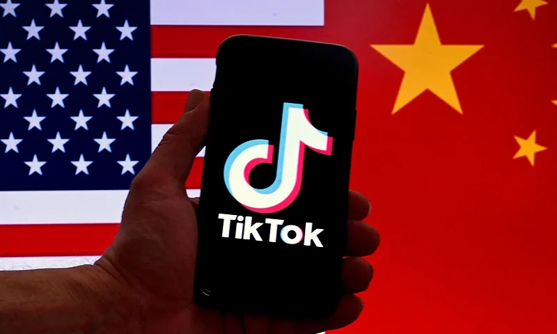 In this photo illustration the social media application logo for TikTok is displayed on the screen of an iPhone in front of a US flag and Chinese flag background in Washington, DC, on March 16, 2023. - China urged the United States to stop "unreasonably suppressing" TikTok on March 16, 2023, after Washington gave the popular video-sharing app an ultimatum to part ways with its Chinese owners or face a nationwide ban. (Photo by OLIVIER DOULIERY / AFP) (Photo by OLIVIER DOULIERY/AFP via Getty Images)
