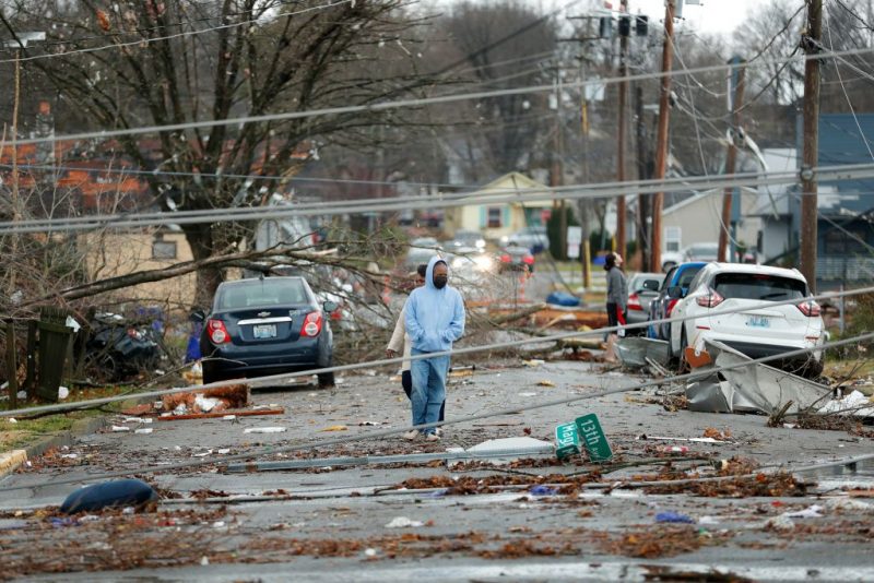 Bowling Green, Kentucky, residents look at the damage following a tornado that struck the area on December 11, 2021. - Tornadoes ripped through five US states overnight, leaving more than 70 people dead Saturday in Kentucky and causing multiple fatalities at an Amazon warehouse in Illinois that suffered "catastrophic damage" with around 100 people trapped inside. The western Kentucky town of Mayfield was "ground zero" of the storm -- a scene of "massive devastation," one official said. (Photo by Gunnar Word / AFP) (Photo by GUNNAR WORD/AFP via Getty Images)