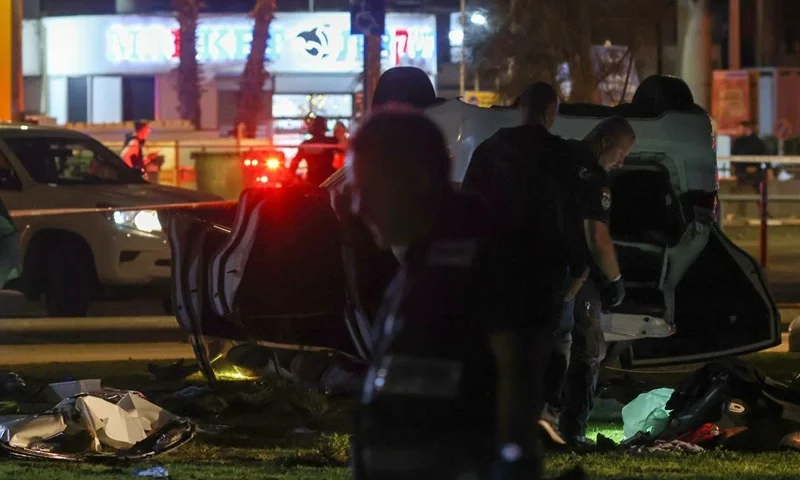 Israeli police gather around an overturned car at the site of an attack in Tel Aviv on April 7, 2023. - One man was killed and four people were wounded in an attack in central Tel Aviv, Israeli rescue services said, updating a previous casualty toll of two injured. (Photo by Oren ZIV / AFP) (Photo by OREN ZIV/AFP via Getty Images)