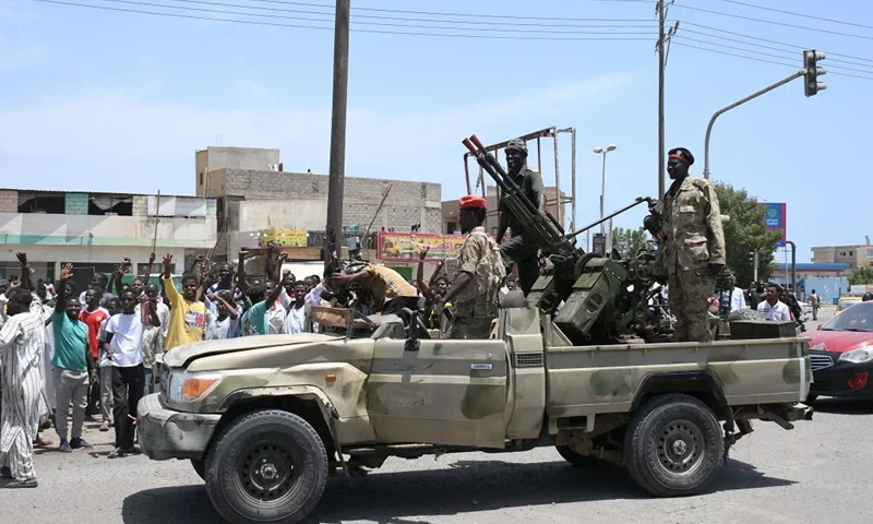 TOPSHOT - Sudanese greet army soldiers, loyal to army chief Abdel Fattah al-Burhan, in the Red Sea city of Port Sudan on April 16, 2023. - Battling fighters in Sudan said they had agreed to an hours-long humanitarian pause, including to evacuate wounded, on the second day of raging urban battles that killed more than 50 civilians including three UN staff and sparking international outcry. (Photo by AFP) (Photo by -/AFP via Getty Images)
