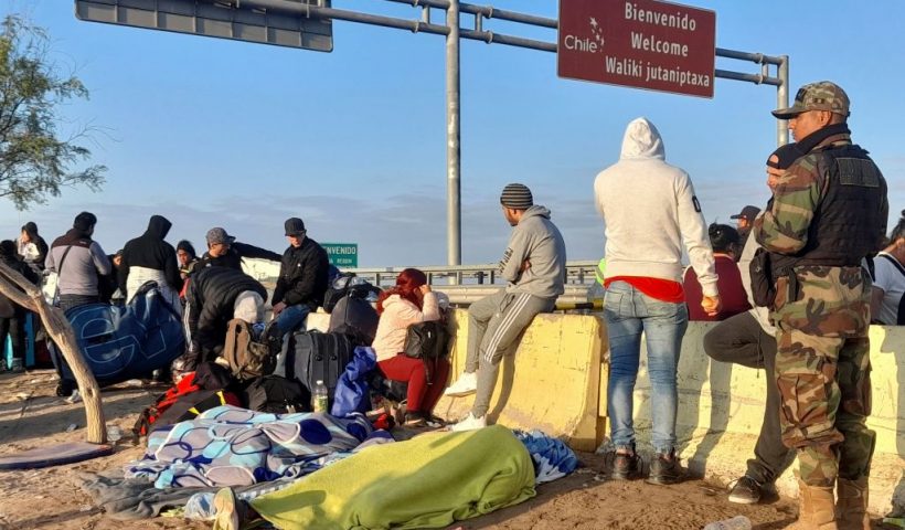 Undocumented migrants of various nationalities remain stranded in the no-man's land between the Chile-Peru border, close to the Peruvian city of Tacna, where they were detained at the border by Peruvian police on April 20, 2023. - Peru's Interior Minister Vicente Romero announced on April 19 that the government mobilized some 200 police officers at its border with Chile in response to the arrival of dozens of undocumented Venezuelan and Colombian migrants who say they want to return to their home countries. The people left Chile as the country implemented increased migration controls. (Photo by Javier Rumiche / AFP) (Photo by JAVIER RUMICHE/AFP via Getty Images)