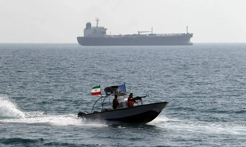 Iranian Revolutionary Guards drive a speedboat in front of an oil tanker during a ceremony to commemorate the 24th anniversary of the downing of Iran Air flight 655 by the US navy, at the port of Bandar Abbas on July 2, 2012. The plane was shot down by mistake over the Gulf by the US navy's guided missile cruiser, USS Vincennes, during confrontation with Iranian speedboats on July 3, 1988, killing 290 civilian passengers and crew members. AFP PHOTO/ATTA KENARE (Photo by Atta KENARE / AFP) (Photo by ATTA KENARE/AFP via Getty Images)
