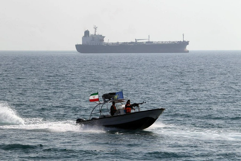 Iranian Revolutionary Guards drive a speedboat in front of an oil tanker during a ceremony to commemorate the 24th anniversary of the downing of Iran Air flight 655 by the US navy, at the port of Bandar Abbas on July 2, 2012. The plane was shot down by mistake over the Gulf by the US navy's guided missile cruiser, USS Vincennes, during confrontation with Iranian speedboats on July 3, 1988, killing 290 civilian passengers and crew members. AFP PHOTO/ATTA KENARE (Photo by Atta KENARE / AFP) (Photo by ATTA KENARE/AFP via Getty Images)