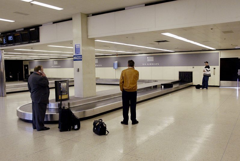Passengers wait for their luggage at the U.S. Airways baggage carousel at O'Hare International Airport March 24, 2003 in Chicago, Illinois. Airline stocks dropped after Delta Airlines announced a reduction of services March 24, following similar cutbacks made recently by Continental, Northwest and United Airlines. (Photo by Scott Olson/Getty Images)