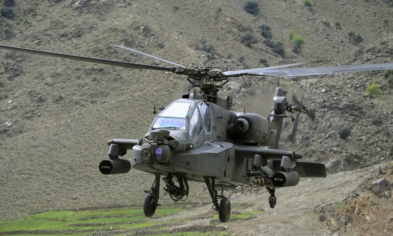A US Army AH-64 Apache helicopter flies over the mountains near the ISAF's Camp Bostick in Naray, in Afghanistan's eastern Kunar province on April 13, 2009. US President Barack Obama, unveiling his new strategy for the dragging Afghan war last month, put Pakistan at the heart of the fight to defeat Al-Qaeda and vowed to boost US aid and assistance to the South Asian nation. AFP PHOTO/LIU Jin (Photo credit should read LIU JIN/AFP via Getty Images)