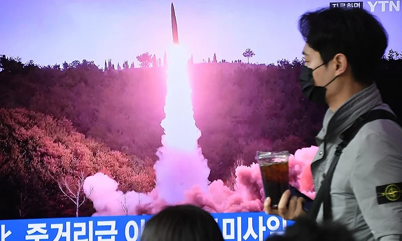TOPSHOT - A man walks past a television screen showing a news broadcast with file footage of a North Korean missile test, at a railway station in Seoul on April 13, 2023. - North Korea fired a ballistic missile on April 13, Seoul's military said, prompting Japan to briefly issue a seek shelter warning to residents of the northern Hokkaido region. (Photo by JUNG YEON-JE/AFP via Getty Images)
