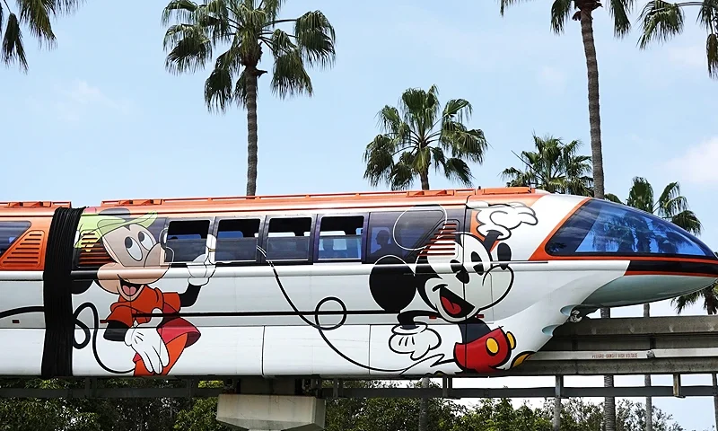 ANAHEIM, CALIFORNIA - APRIL 24: The Disneyland monorail passes near palm trees on April 24, 2023 in Anaheim, California. Disney will lay off several thousand workers this week amid an overall push by the media giant to cut 7,000 total jobs in an effort to save $5.5 billion in costs. (Photo by Mario Tama/Getty Images)