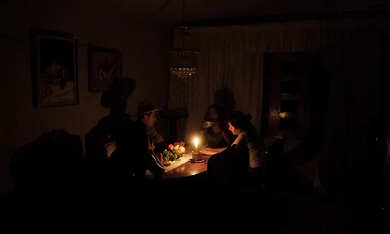 A family sit at a candle lit table in the state of Barinas, 600 km west of Caracas on April 25, 2016. Recession-hit Venezuela will turn off the electricity supply in its 10 most populous states for four hours a day for 40 days to deal with a severe power shortage, the government said. It is the latest drastic measure by the government in a crisis that already has Venezuelans queuing for hours to buy scarce supplies in shops.(Photo by JUAN BARRETO/AFP via Getty Images)