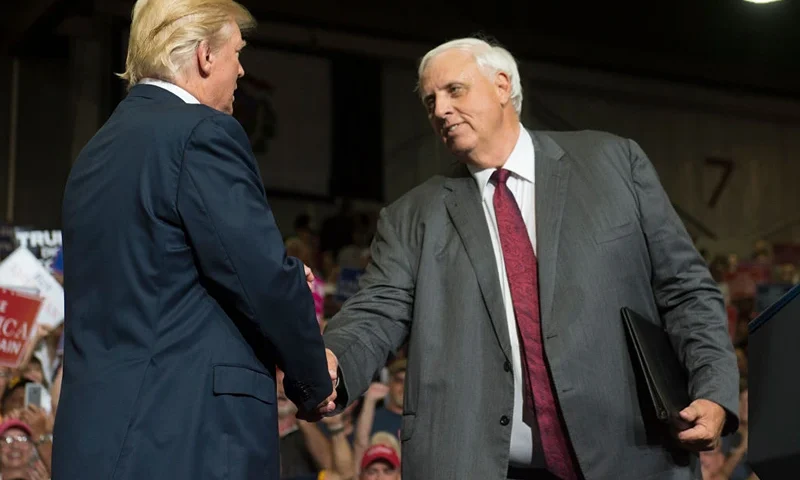 US President Donald Trump shakes hands with West Virginia Governor Jim Justice, who announced during the rally he would switch parties from Democrat to Republican, during a Make America Great Again Rally at Big Sandy Superstore Arena in Huntington, West Virginia, August 3, 2017. / AFP PHOTO / SAUL LOEB (Photo credit should read SAUL LOEB/AFP via Getty Images)