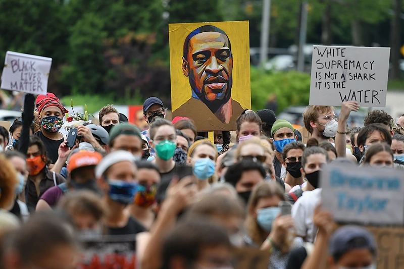 TOPSHOT - A protester holds up a portrait of George Floyd during a "Black Lives Matter" demonstration in front of the Brooklyn Library and Grand Army Plaza on June 5, 2020 in Brooklyn, New York, amid ongoing protests over Floyd's death in police custody. - The United States has seen more than a week of nationwide protests over the death in police custody of George Floyd, captured in a shocking video showing white officer Derek Chauvin kneeling on Floyd's neck for nearly nine minutes as he pleaded for his life. (Photo by Angela Weiss / AFP via Getty Images)