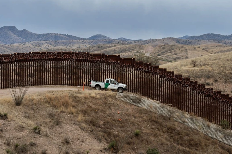 A Border Patrol officer sits inside his car as he guards the US/Mexico border fence, in Nogales, Arizona, on February 9, 2019. (Photo by Ariana Drehsler / AFP) (Photo by ARIANA DREHSLER/AFP via Getty Images)
