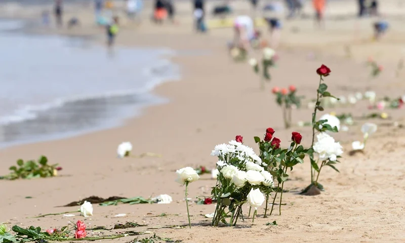 This picture taken on June 10, 2019 shows flowers laid on a beach in Les Sables-d'Olonne, in tribute to three rescuers killed on June 7, when a SNSM vessel capsized in rough seas as a giant storm pummelled the country's Atlantic coast. - The SNSM team had been attempting to help a fishing boat which was struggling in the giant swell caused by storm Miguel, which was packing winds of up to 120 kilometres an hour (75 mph). In late morning, a boat from the SNSM capsized 800 metres from the coast around Les Sables-d'Olonne with seven people on board. Three of them died while four managed to swim to shore, the statement added. (Photo by Sebastien SALOM-GOMIS / AFP) (Photo credit should read SEBASTIEN SALOM-GOMIS/AFP via Getty Images)