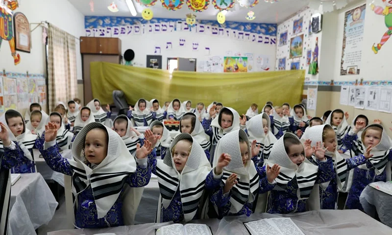 Ultra-Orthodox Jewish children dressed in costumes celebrating Purim sit in a classroom at their school, two days ahead of the official holiday, in the Mea Shearim neighbourhood in Jerusalem on March 8, 2020. - The carnival-like Purim holiday is celebrated with parades and costume parties to commemorate biblical story of the deliverance of the Jewish people from a plot to exterminate them in the ancient Persian empire 2,500 years ago, as recorded in the Book of Esther. (Photo by MENAHEM KAHANA / AFP) (Photo by MENAHEM KAHANA/AFP via Getty Images)