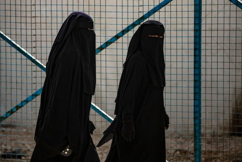 Women walk at the Kurdish-run al-Hol camp which holds suspected relatives of Islamic State (IS) group fighters, in Hasakeh governorate of northeastern Syria, on March 3, 2021. - At least 31 killings have rocked al-Hol camp since early January, a Kurdish official said today, with aid groups warning of a "nightmare". It was the latest evidence of deteriorating security at the camp in the Kurdish-run northeast, where Medecins Sans Frontieres (MSF) had to temporarily suspend operations this week after the killing of one of its team members. (Photo by Delil SOULEIMAN / AFP) (Photo by DELIL SOULEIMAN/AFP via Getty Images)
