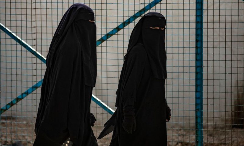 Women walk at the Kurdish-run al-Hol camp which holds suspected relatives of Islamic State (IS) group fighters, in Hasakeh governorate of northeastern Syria, on March 3, 2021. - At least 31 killings have rocked al-Hol camp since early January, a Kurdish official said today, with aid groups warning of a "nightmare". It was the latest evidence of deteriorating security at the camp in the Kurdish-run northeast, where Medecins Sans Frontieres (MSF) had to temporarily suspend operations this week after the killing of one of its team members. (Photo by Delil SOULEIMAN / AFP) (Photo by DELIL SOULEIMAN/AFP via Getty Images)