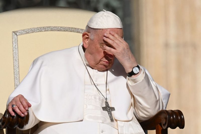 Pope Francis protects his face from the sun at the start of the weekly general audience on April 12, 2023 at St. Peter's square in The Vatican. (Photo by Vincenzo PINTO / AFP) (Photo by VINCENZO PINTO/AFP via Getty Images)