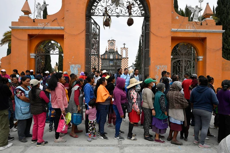 Residents line up to receive a protection kit in case of ash fall in the village of Santiago Xalitzintla in Puebla state, Mexico on May 23, 2023 (Photo by CLAUDIO CRUZ/AFP via Getty Images)