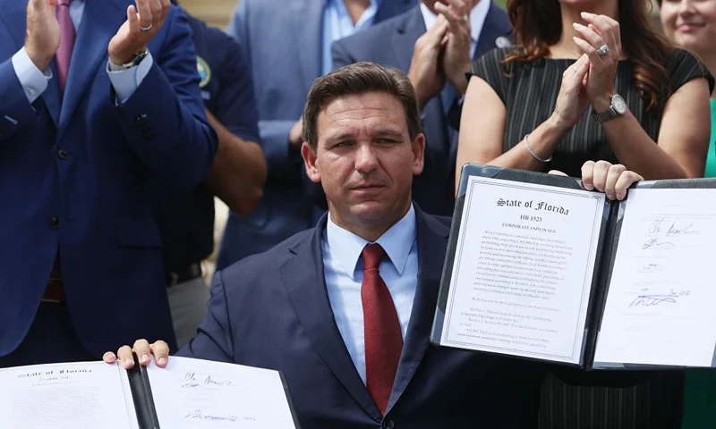 MIAMI, FLORIDA - JUNE 07: Florida Gov. Ron DeSantis holds up two bills he signed at the Florida National Guard Robert A. Ballard Armory on June 07, 2021 in Miami, Florida. The governor signed the bills to combat foreign influence and corporate espionage in Florida from governments like China. (Photo by Joe Raedle/Getty Images)