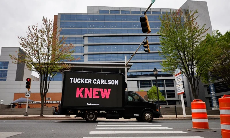 WILMINGTON, DELAWARE - APRIL 17: A truck with a digital sign saying, 'Tucker Carlson KNEW' drives past the Leonard Williams Justice Center where Delaware Superior Court Judge Eric Davis postposed the start of the Dominion Voting Systems defamation trial against FOX News for 24 hours on April 17, 2023 in Wilmington, Delaware. Dominion is seeking $1.6 billion in damages, claiming defamation by FOX when the network broadcast false claims that it was tied to late Venezuelan President Hugo Chavez. FOX also claimed Dominion paid kickbacks to politicians and that its voting machines were "rigged" to switch millions of votes from Donald Trump to Joe Biden in the 2020 election. (Photo by Chip Somodevilla/Getty Images)