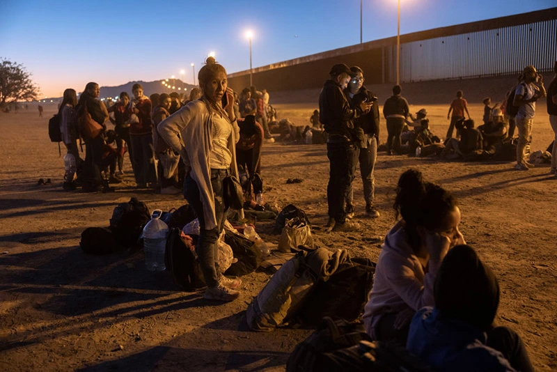 EL PASO, TEXAS - MAY 08: Immigrants seeking asylum in the United States wait near the U.S. Mexico border fence, hoping to be processed by U.S. border agents to make asylum claims on May 08, 2023 in El Paso, Texas. A surge of immigrants is expected with the end of the U.S. government's Covid-era Title 42 policy, which for the past three years has allowed for the quick expulsion of irregular migrants entering the country. (Photo by John Moore/Getty Images)