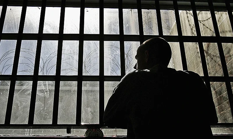 19 year old inmate James looks out of the window of the Young Offenders Institution attached to Norwich Prison on August 25, 2005 in Norwich, England. A Chief Inspector of Prisons report on Norwich Prison says healthcare accommodation was among the worst seen, as prisoners suffered from unscreened toilets, little natural light, poor suicide prevention, inadequate education and training for long-term prisoners. (Photo by Peter Macdiarmid/Getty Images)