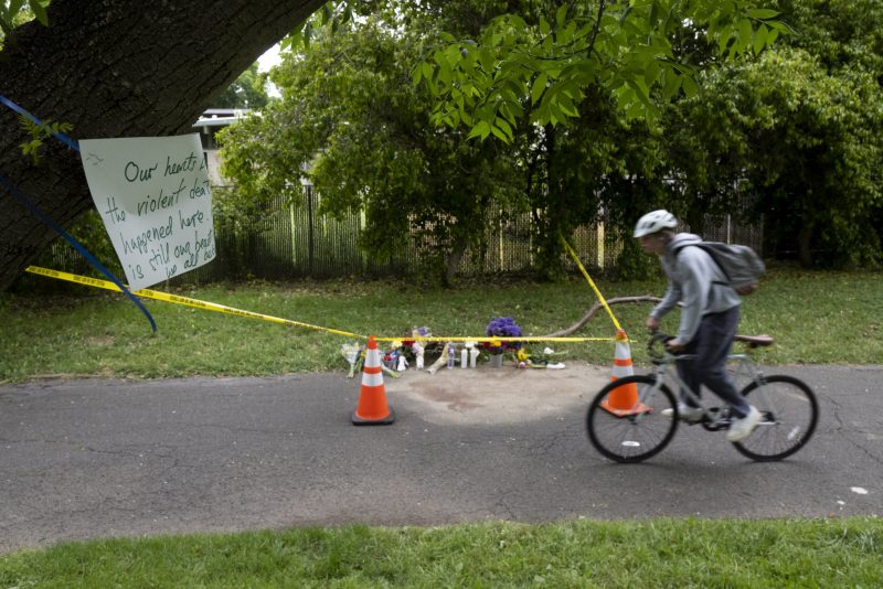 A cyclist rides past a memorial of flowers, Monday, May 1, 2023, marking the location that Karim Abou Najm, a graduating senior at UC Davis, was fatally stabbed in Sycamore Park in Davis, Calif. It was the city's second deadly stabbing at a park in three days. Residents of the Northern California university town are on edge after three people were stabbed within a week, including two fatally. (Paul Kitagaki Jr./The Sacramento Bee via AP)