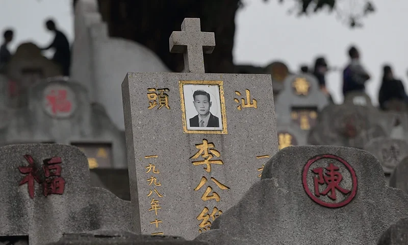 Families attend graves at the Diamond Hill Cemetery in Hong Kong on April 5, 2023 as people visit cemeteries to honour their ancestors during the annual Tomb Sweeping Day, known locally in Hong Kong as Ching Ming. (Photo by Peter PARKS / AFP) (Photo by PETER PARKS/AFP via Getty Images)