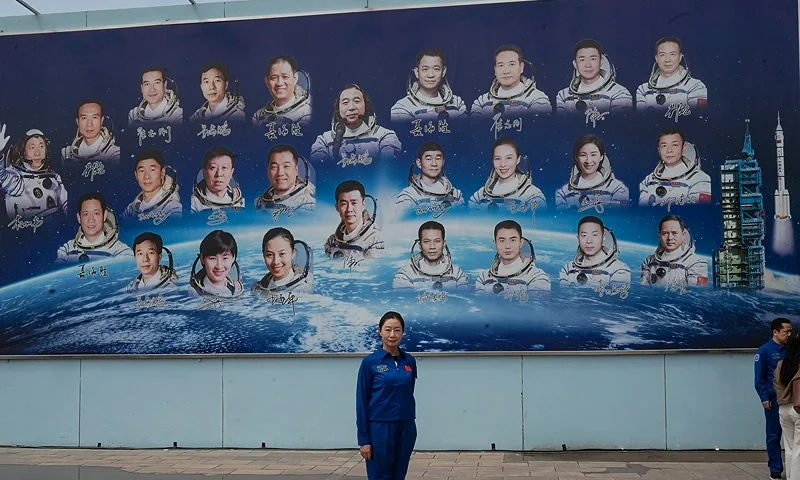 An employee of the China Manned Space Agency takes photos in front of a board showing the countrys astronauts after a pre-launch press conference for the Shenzhou-16 mission at the Jiuquan Satellite Launch Center on May 29, 2023 in Jiuquan, China. The astronauts will travel on the Shenzhou-16 spacecraft carried by a Long March-2F rocket to Chinas Tiangong Space Station from the Gobi Desert on May 30 and will stay for six months, relieving the crew that arrived there late in 2022. (Photo by Kevin Frayer/Getty Images)