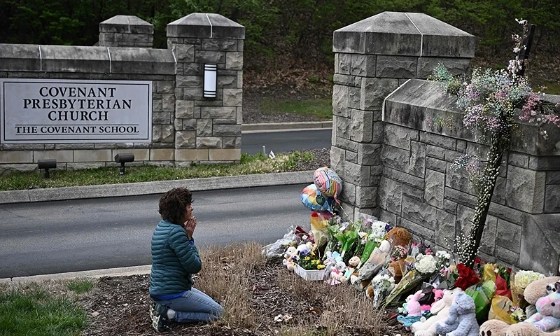 TOPSHOT - Robin Wolfenden prays at a makeshift memorial for victims outside the Covenant School building at the Covenant Presbyterian Church following a shooting, in Nashville, Tennessee, on March 28, 2023. - A heavily armed former student killed three young children and three staff in what appeared to be a carefully planned attack at a private elementary school in Nashville on March 27, before being shot dead by police. Chief of Police John Drake named the suspect as Audrey Hale, 28, who the officer later said identified as transgender. (Photo by BRENDAN SMIALOWSKI/AFP via Getty Images)