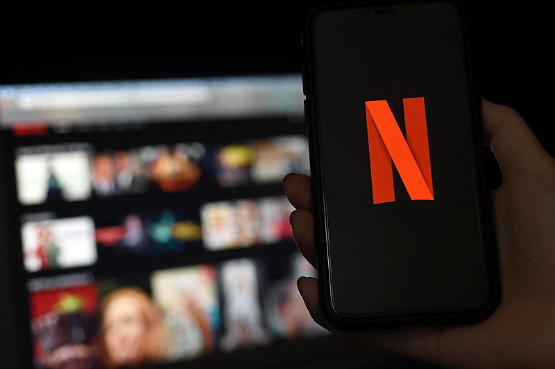 In this photo illustration a computer and a mobile phone screens display the Netflix logo on March 31, 2020 in Arlington, Virginia. (Photo by OLIVIER DOULIERY/AFP via Getty Images)