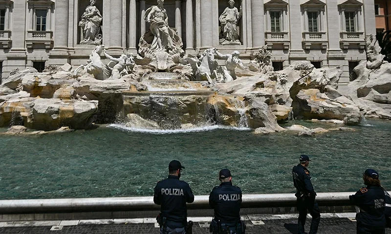Police stands guard on May 21, 2023 at the Fontana di Trevi fountain in downtown Rome after environmental activists of Last Generation (Ultima Generazione) poured black liquid made out of vegetable-based carbon into the water as part of a campaign to raise awareness about climate change. (Photo by FILIPPO MONTEFORTE/AFP via Getty Images)