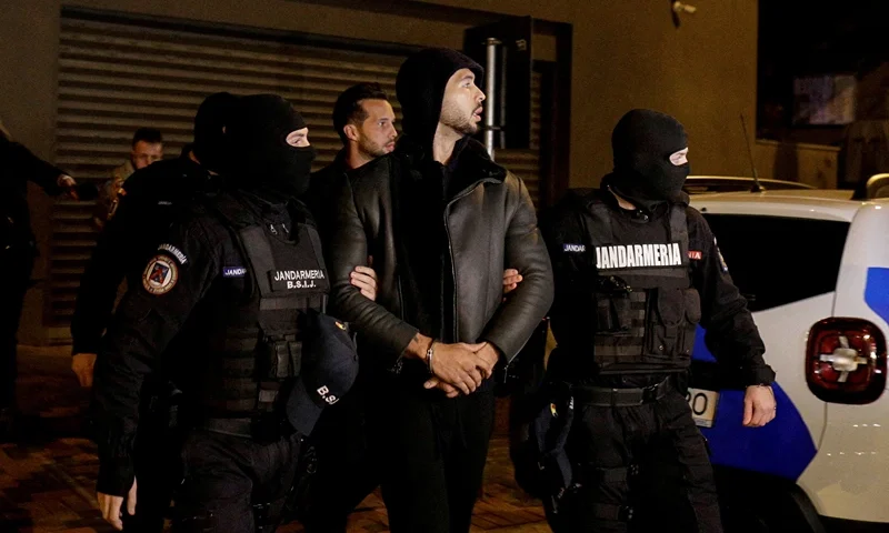 Andrew Tate and Tristan Tate are escorted by police officers outside the headquarters of the Directorate for Investigating Organized Crime and Terrorism in Bucharest (DIICOT) after being detained for 24 hours, in Bucharest, Romania, December 29, 2022. Inquam Photos/Octav Ganea via REUTERS/File Photo