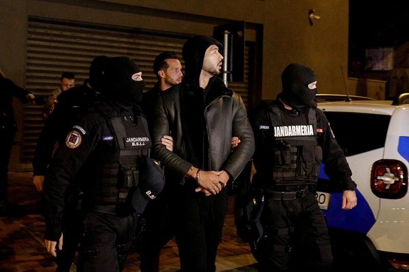  Andrew Tate and Tristan Tate are escorted by police officers outside the headquarters of the Directorate for Investigating Organized Crime and Terrorism in Bucharest (DIICOT) after being detained for 24 hours, in Bucharest, Romania, December 29, 2022. Inquam Photos/Octav Ganea via REUTERS/File Photo
