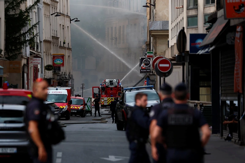 French police secure the area as firefighters work after several buildings on fire following a gas explosion in the fifth arrondissement of Paris, France, June 21, 2023. REUTERS/Gonzalo Fuentes