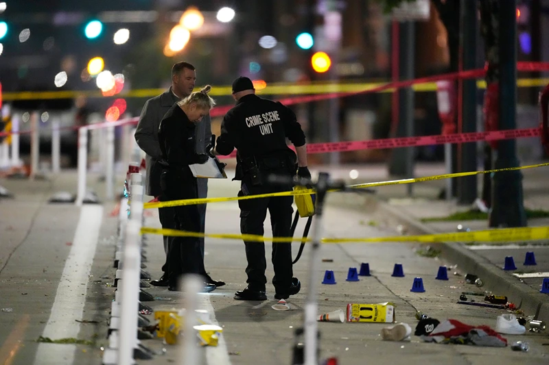 Denver Police Department investigators work on the scene of a mass shooting along Market Street between 20th and 21st avenues during a celebration after the Denver Nuggets won the team's first NBA Championship early Tuesday, June 13, 2023, in Denver. (AP Photo/David Zalubowski)