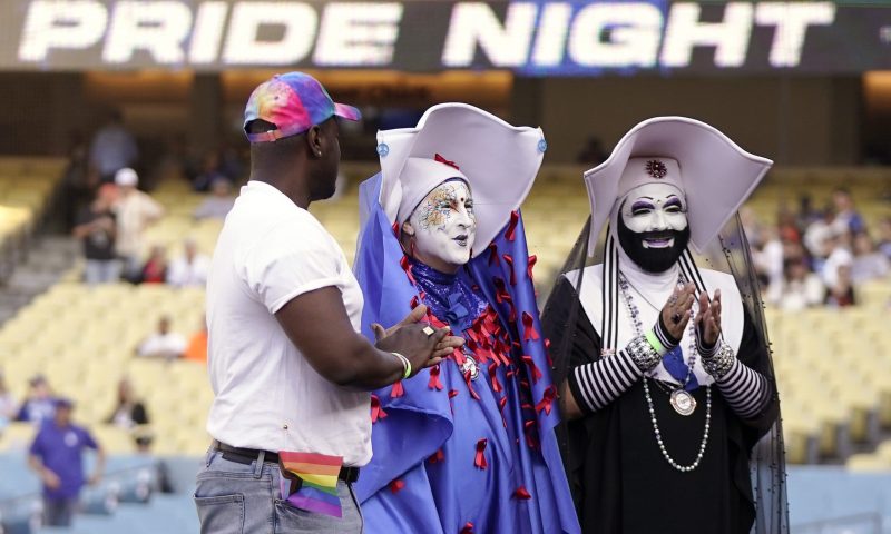 Gerald Garth, left, stands with members of the Sisters of Perpetual Indulgence, Sister Unity, center, and Sister Dominia as they honored during LGBTQ+ Pride Night prior to a baseball game between the Los Angeles Dodgers and the San Francisco Giants Friday, June 16, 2023, in Los Angeles. (AP Photo/Mark J. Terrill)