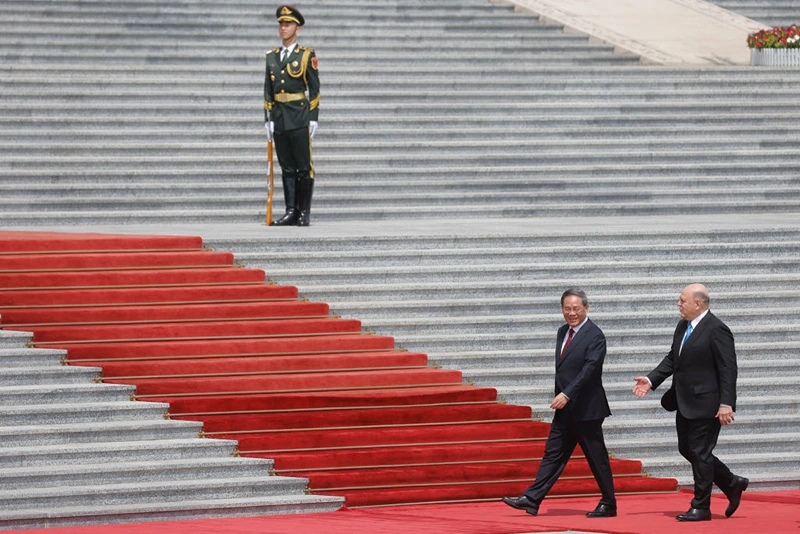 TOPSHOT - Russian Prime Minister Mikhail Mishustin (R) and Chinese Premier Li Qiang attend a welcoming ceremony in Beijing on May 24, 2023. (Photo by THOMAS PETER / POOL / AFP) (Photo by THOMAS PETER/POOL/AFP via Getty Images)