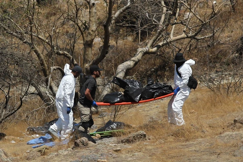 Forensic experts work with several bags of human remains extracted from the bottom of a ravine by a helicopter, which were abandoned at the Mirador Escondido community in Zapopan, Jalisco state, Mexico on May 31, 2023. The Jalisco Prosecutor's Office is investigating to find out if the remains belong to the 7 call center workers who disappeared on their way to work in recent days. (Photo by ULISES RUIZ / AFP) (Photo by ULISES RUIZ/AFP via Getty Images)
