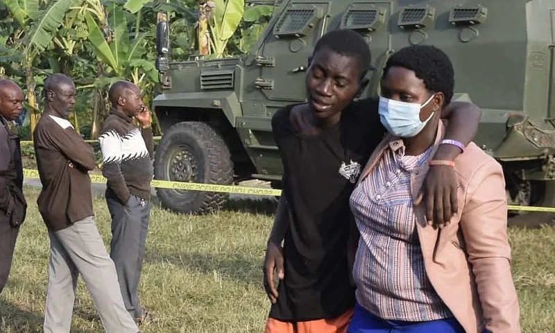 TOPSHOT - A boy is conforted at the scene of an attack in Mpondwe, Uganda, on June 17, 2023 at the Mpondwe Lhubiriha Secondary School. The death toll from an attack on a school in western Uganda by militants linked to the Islamic State group has risen to 37, the country's army spokesman said Saturday. (Photo by AFP) (Photo by -/AFP via Getty Images)