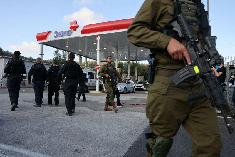 Israeli soldiers and police walk at a petrol station at the scene of an attack near the Jewish settlement of Eli in the north of the occupied West Bank on June 20, 2023. Four people were shot dead on June 20 near the settlement in the occupied West Bank, Israeli officials said, a day after an army raid left six Palestinians dead. (Photo by AHMAD GHARABLI / AFP) (Photo by AHMAD GHARABLI/AFP via Getty Images)