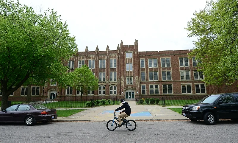 A boy on a bike passes the Wilbur Wright Elementary School May 8, 2013 in Cleveland, Ohio, where Gina DeJesus attended classes a decade ago, before she went missing. US police interrogated three brothers Wednesday as grim details began to emerge about how three young Ohio women were kidnapped and held captive for 10 years in an unremarkable city home. Amanda Berry, 27, Gina DeJesus, 23, and Michelle Knight, 32, were freed from a home on Cleveland's Seymour Avenue on Monday, nearly ten years after they had each disappeared in separate incidents. The occupant of the home, a 52-year-old former school bus driver of Puerto Rican origin, Ariel Castro, has been arrested, along with his brothers, Pedro, 54, and Onil, 50. AFP PHOTO/Emmanuel Dunand (Photo by EMMANUEL DUNAND/AFP via Getty Images)