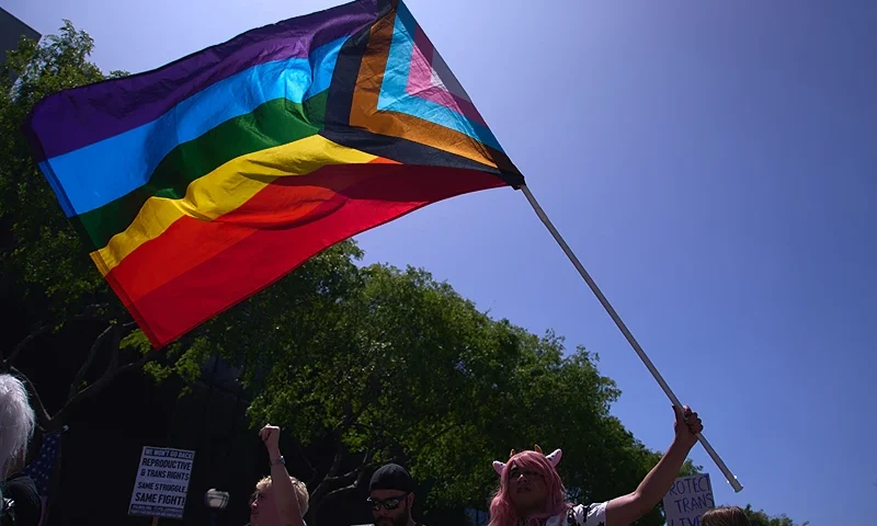 A Progress Pride Flag is held above the crowd of LGBTQ+ activists during the Los Angeles LGBT Center's "Drag March LA: The March on Santa Monica Boulevard", in West Hollywood, California, on Easter Sunday April 9, 2023. - The march comes in response to more than 400 pieces of legislation targeting the LGBTQ+ community that government officials across the United States have proposed or passed in 2023. (Photo by ALLISON DINNER / AFP) (Photo by ALLISON DINNER/AFP via Getty Images)