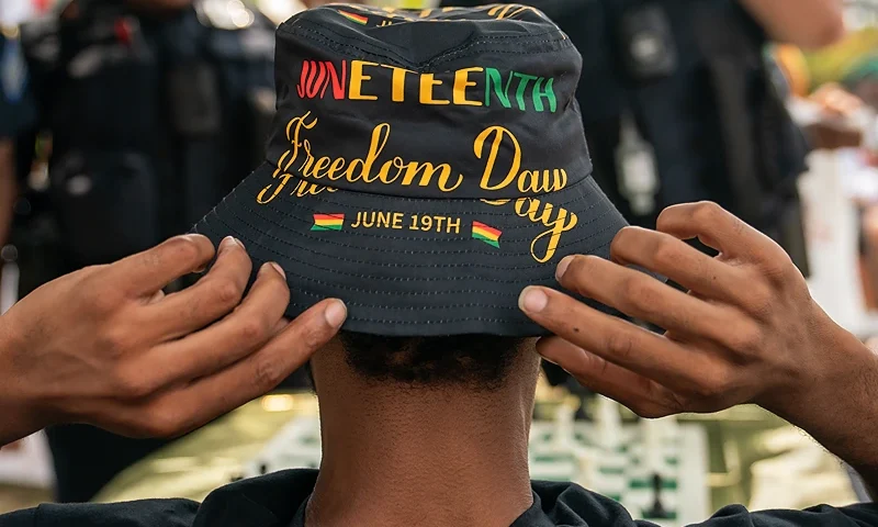 WASHINGTON, DC - JUNE 17: An attendee adjusts his Juneteenth-themed hat during a neighborhood Juneteenth festival on June 17, 2023 in Washington, DC. Two years ago, President Joe Biden signed bipartisan legislation establishing Juneteenth as a federal holiday. Juneteenth commemorates the day on June 19, 1865 when a Union general read orders in Galveston, Texas stating all enslaved people in the state were free according to federal law. (Photo by Nathan Howard/Getty Images)